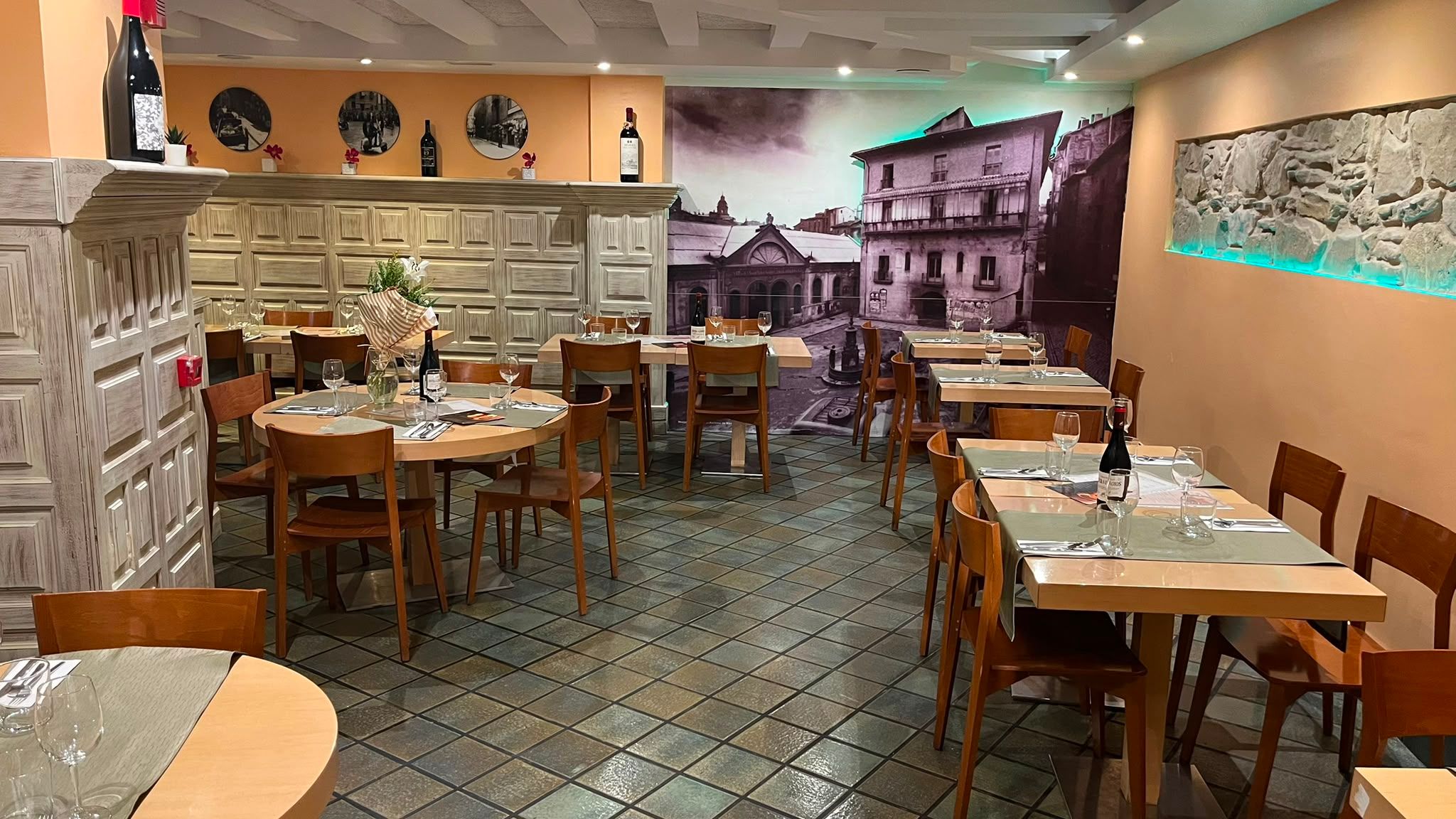 El comedor visto desde la entrada, con las mesas puestas y flores en el centro de la redonda.